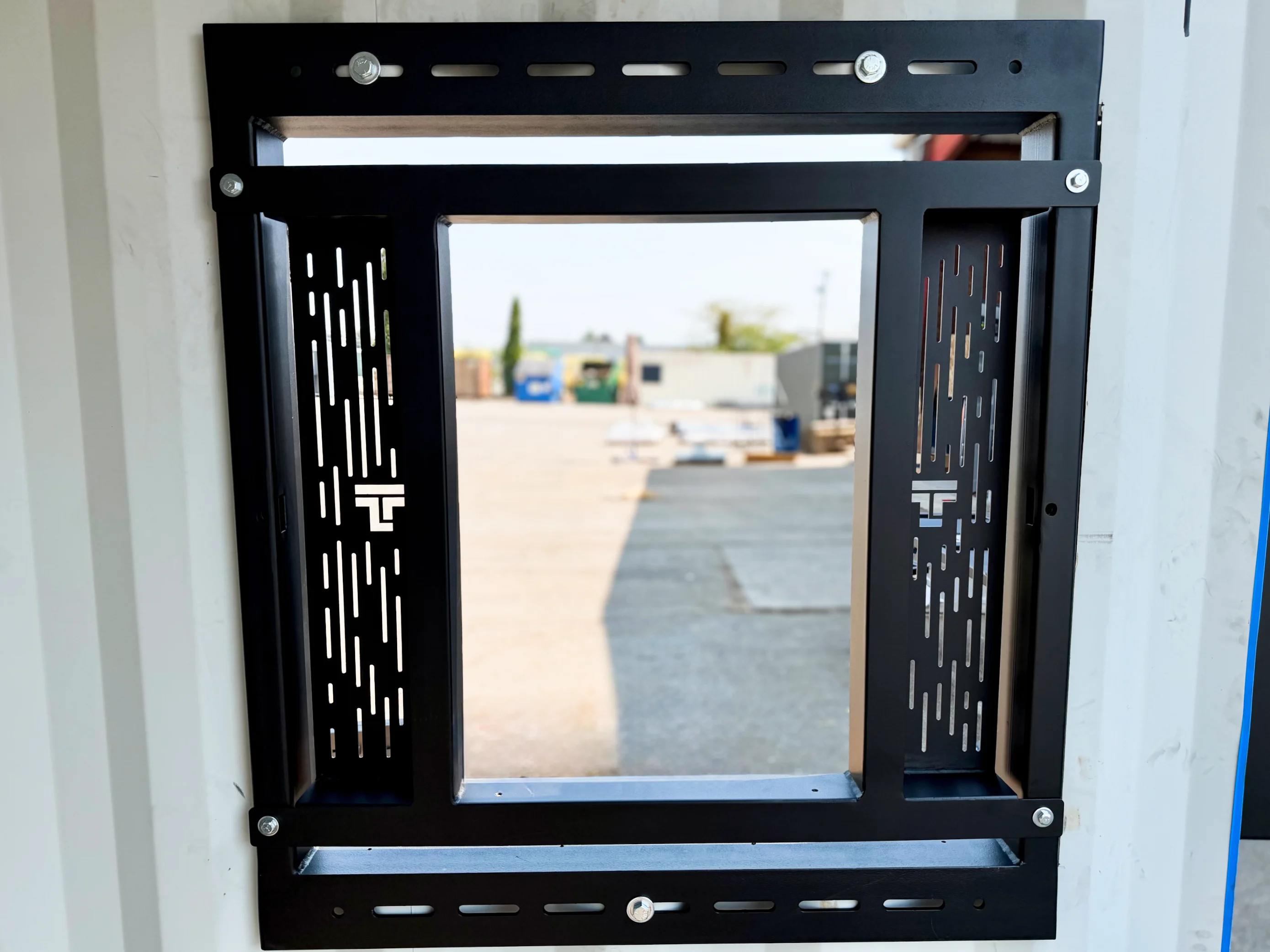 Taylor'd Training Window installed on a container corner, shutters open, yard view